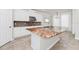 Bright kitchen with a beautiful island, mosaic backsplash, stainless steel appliances, and stylish lighting at 5552 Remsen Cay Ln, Windermere, FL 34786