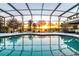 Screened-in pool with sunset views over the lake at 5552 Remsen Cay Ln, Windermere, FL 34786