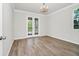 An open room with hardwood floors, white trim, and French doors to the outdoor area at 5552 Remsen Cay Ln, Windermere, FL 34786
