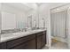 Bathroom featuring double vanity sinks with granite countertops and a shower at 5846 Sw 80Th Ln, Ocala, FL 34476