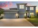 Beautiful two-story home featuring a three-car garage and manicured lawn at sunset at 5846 Sw 80Th Ln, Ocala, FL 34476