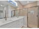 Bathroom featuring double sinks, a walk-in shower with glass door, and natural light from a transom window at 6291 Sw 133Rd Street Road, Ocala, FL 34473