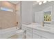 Well-lit bathroom showcasing a tub and shower combo, complemented by a stylish vanity and decorative mirror at 6291 Sw 133Rd Street Road, Ocala, FL 34473