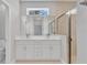 Bathroom featuring double sinks, a walk-in shower with glass door, and natural light from a transom window at 6291 Sw 133Rd Street Road, Ocala, FL 34473