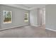 Bedroom with carpet, tray ceilings, natural light from two windows, and doorway to another room at 6291 Sw 133Rd Street Road, Ocala, FL 34473