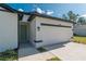 White home with light blue front door, dark trim, and attached two-car garage at 6291 Sw 133Rd Street Road, Ocala, FL 34473