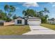 Inviting home with white exterior, dark accents, a long driveway, and well-manicured lawn at 6291 Sw 133Rd Street Road, Ocala, FL 34473