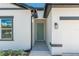 Close-up of the entrance with a light blue door, white stucco, and black trim at 6291 Sw 133Rd Street Road, Ocala, FL 34473