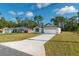 Inviting home with white exterior, dark accents, a long driveway, and well-manicured lawn at 6291 Sw 133Rd Street Road, Ocala, FL 34473