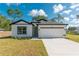 Beautiful white house with black accents, a two-car garage, and a well-maintained lawn at 6291 Sw 133Rd Street Road, Ocala, FL 34473