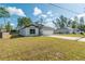 Inviting home with white exterior, dark accents, a long driveway, and well-manicured lawn at 6291 Sw 133Rd Street Road, Ocala, FL 34473
