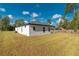 Side view of home's exterior showing windows, lawn, and covered back patio at 6291 Sw 133Rd Street Road, Ocala, FL 34473