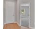 A home entry way with light wood floors leading to a carpeted room through a white trimmed doorway at 6291 Sw 133Rd Street Road, Ocala, FL 34473