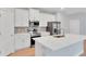 Modern kitchen with stainless steel appliances, white cabinets, an island, and a stylish backsplash for a clean, updated look at 6291 Sw 133Rd Street Road, Ocala, FL 34473