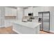 Beautiful kitchen island featuring stainless steel appliances, sleek white cabinetry, and a large island with quartz countertops at 6291 Sw 133Rd Street Road, Ocala, FL 34473