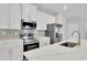 Modern kitchen featuring stainless steel appliances, white cabinetry, and a center island with a sink at 6291 Sw 133Rd Street Road, Ocala, FL 34473