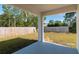 Covered patio overlooks a well-maintained backyard with a wood privacy fence at 6291 Sw 133Rd Street Road, Ocala, FL 34473