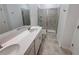 A modern bathroom featuring a double vanity, tiled floors, and a glass door shower at 6300 Chirpine Ln, St Cloud, FL 34771