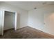 Bedroom with neutral carpet, white walls, closet, and entry door at 6300 Chirpine Ln, St Cloud, FL 34771