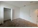 Bedroom with neutral carpet, white walls, closet, and entry door at 6300 Chirpine Ln, St Cloud, FL 34771