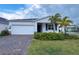 Charming single-Gathering home with a two-car garage, brick paver driveway and tropical landscaping at 6300 Chirpine Ln, St Cloud, FL 34771