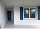 Charming front porch, featuring a vibrant blue door and matching shutters, creating a welcoming entrance at 6300 Chirpine Ln, St Cloud, FL 34771