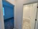 A hallway leading to a carpeted room and a full bathroom with a tiled shower and tub at 6300 Chirpine Ln, St Cloud, FL 34771