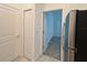 Hallway view leading to bedroom, featuring stainless steel refrigerator and ample cabinet space at 6300 Chirpine Ln, St Cloud, FL 34771