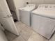 Laundry room with white washer and dryer on tile flooring at 6300 Chirpine Ln, St Cloud, FL 34771