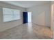 Bright and open living room showcasing neutral tile flooring, large windows, and a vibrant blue door at 6300 Chirpine Ln, St Cloud, FL 34771