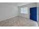 Bright living room features neutral tile flooring, large window, and a vibrant blue door, creating a welcoming atmosphere at 6300 Chirpine Ln, St Cloud, FL 34771