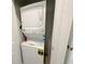 A stacked white washer and dryer sit in a small utility area, ready for laundry needs at 6300 Chirpine Ln, St Cloud, FL 34771