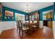 Vibrant dining room with bold blue walls, classic wainscoting, and a view into the kitchen at 811 Oregon St, Orlando, FL 32803