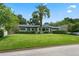 Single-story home with a large green lawn and a mature palm tree, enhancing the property's tropical feel at 811 Oregon St, Orlando, FL 32803