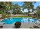 Relaxing backyard retreat featuring a sparkling pool, lush greenery, and a cozy fire pit at 811 Oregon St, Orlando, FL 32803