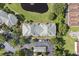 Overhead view shows a meticulously kept apartment complex, landscaped with a beautiful pond and surrounding trees at 8816 Dunes Ct # 303, Kissimmee, FL 34747