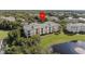 Beautiful, sunny condo building overlooking a serene lake with lush landscaping and a fountain at 8816 Dunes Ct # 303, Kissimmee, FL 34747