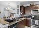 Well-equipped kitchen with granite counters, dark cabinetry, stainless appliances, and seamless flow to dining area at 8816 Dunes Ct # 303, Kissimmee, FL 34747