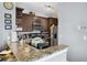 Well-lit kitchen area with granite countertops, dark cabinets, and modern appliances creating a comfortable cooking space at 8816 Dunes Ct # 303, Kissimmee, FL 34747