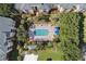 Aerial view of a sparkling pool surrounded by palm trees, lounge chairs, and colorful umbrellas at 8816 Dunes Ct # 303, Kissimmee, FL 34747