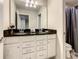 Bathroom featuring a dual sink vanity with granite countertop and modern lighting fixtures at 8911 Geneve Ct, Kissimmee, FL 34747