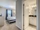 Hallway view into bedroom adjacent to bathroom featuring a vanity with white cabinets and black countertop at 8911 Geneve Ct, Kissimmee, FL 34747