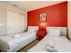 The cozy bedroom with twin beds, bright red accent wall, and playful decor creates a fun and inviting space at 8911 Geneve Ct, Kissimmee, FL 34747