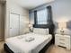 Bright bedroom features a king bed with nightstands, closet, and a window dressed with modern striped curtains at 8911 Geneve Ct, Kissimmee, FL 34747