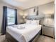 Bright bedroom featuring a plush bed with fresh white linens and stylish bedside tables with lamps at 8911 Geneve Ct, Kissimmee, FL 34747