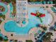 Aerial view of the community pool with multiple lounge chairs, umbrellas, and a colorful water slide at 8911 Geneve Ct, Kissimmee, FL 34747