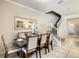 Formal dining area showcases a table set for six, complemented by an elegant mirror, and staircase at 8911 Geneve Ct, Kissimmee, FL 34747