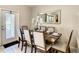 Dining area with a table set for six under a decorative mirror reflecting the outdoor view at 8911 Geneve Ct, Kissimmee, FL 34747