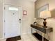 Welcoming entryway featuring tile flooring, a console table with decor, and a bright front door at 8911 Geneve Ct, Kissimmee, FL 34747