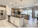 Modern kitchen with stainless steel appliances, a central island, and seamless access to the living area at 8911 Geneve Ct, Kissimmee, FL 34747